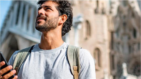 un chico utilizado su móvil para pasear por la ciudad