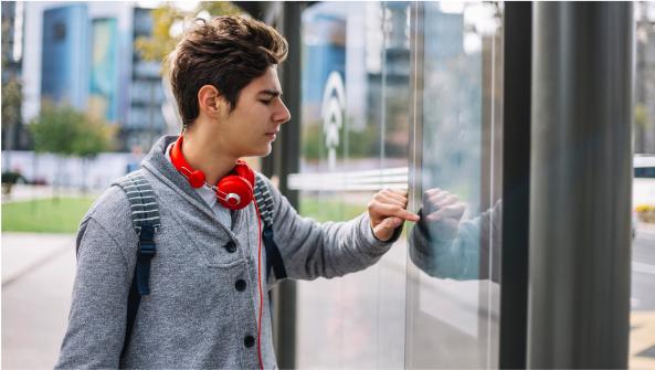 un chico utilizando una pantalla colocada en la calle
