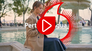 una chica usando su teléfono móvil sentada en una fuente