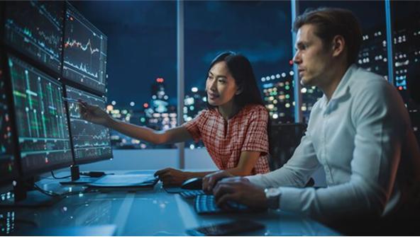 Dos empleados analizando datos en una pantallla