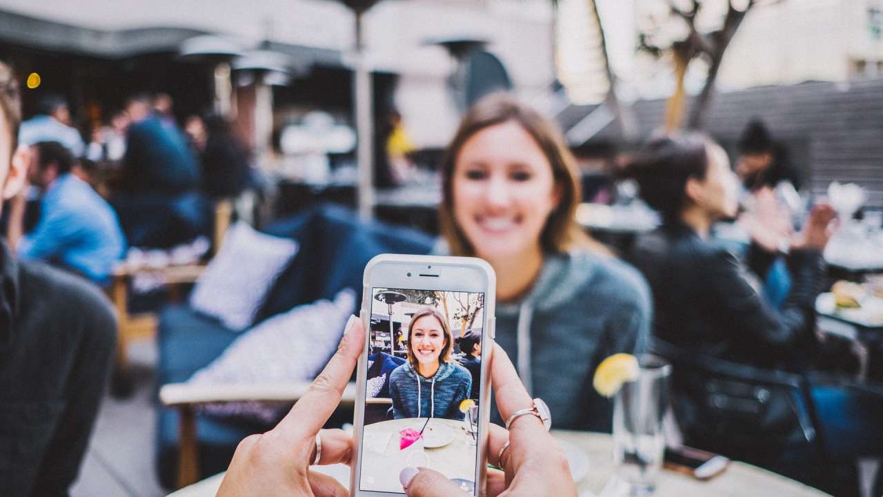 una chica siendo fotografiada por un móvil