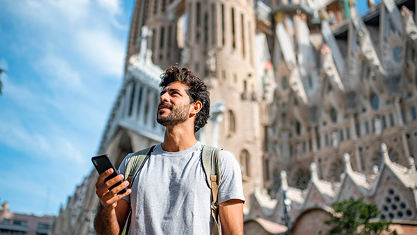 un chico con la sagrada familia de barcelona de fondo