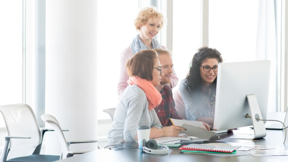 un grupo de personas trabajando frente a un ordenador