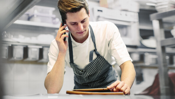 un senyor treballant en el seu negoci mentre parla per telèfon